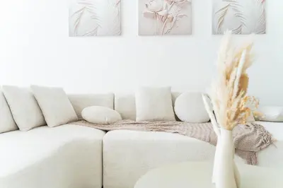 a white couch in a living room with paintings on the wall at Stunning Burj Khalifa View Luxury 2BR Business Bay in Dubai