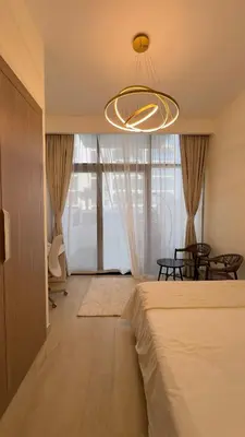 a bedroom with a bed and a chandelier at Luxury Studio big Balcony in Dubai