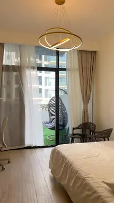 a bedroom with a bed and a table and a large window at Luxury Studio big Balcony in Dubai