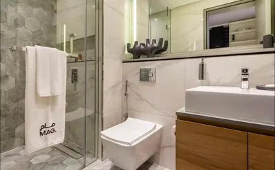 a bathroom with a toilet and a sink and a mirror at Mag318 downtown Luxury-5 Minutes walk to Burj&mall in Dubai