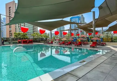 a swimming pool with tables and chairs and umbrellas at Mag318 downtown Luxury-5 Minutes walk to Burj&mall in Dubai