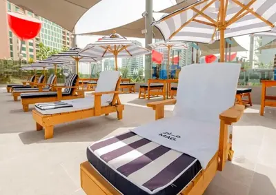 a group of chairs and umbrellas on a patio at Mag318 downtown Luxury-5 Minutes walk to Burj&mall in Dubai