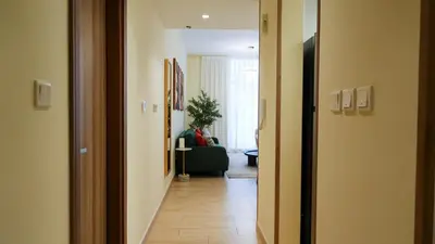 a hallway leading to a living room with a couch at Stunning 2BR Canal & Burj Khalifa Partial View 4 in Dubai
