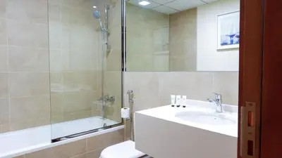 a bathroom with a sink and a shower and a toilet at Stunning 2BR Canal & Burj Khalifa Partial View 4 in Dubai