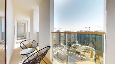 a balcony with two chairs and a view of a city at Modern 2BR City Skyline View 6 in Dubai
