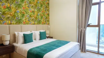 a bedroom with a bed with a painting on the wall at Stunning 2BR Canal & City Skyline View 7 in Dubai