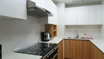 a kitchen with a stove top oven next to a sink at Stunning 2BR Canal & City Skyline View 7 in Dubai