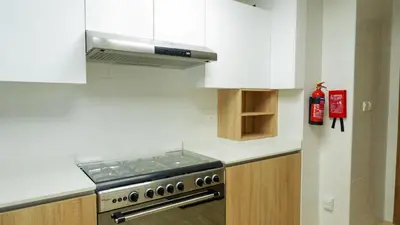 a kitchen with a stove and white cabinets at Elegant 2BR Canal & Burj Khalifa Partial View 5 in Dubai