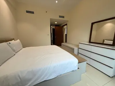 a bedroom with a bed and a dresser with a mirror at Comfort Focused 1BR Laya JVC in Dubai