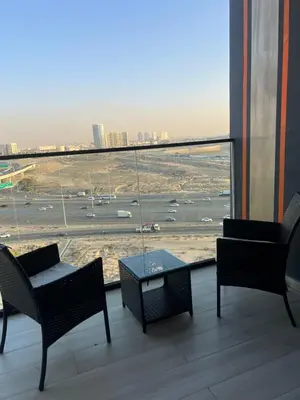 a balcony with chairs and a table and a view of an airport at The Residences in Dubai