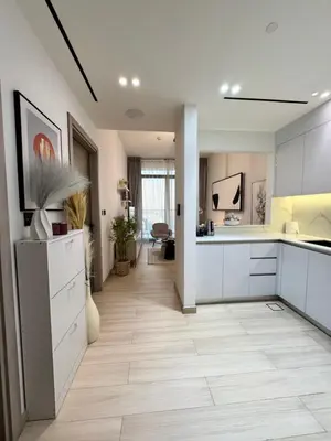an open kitchen with white cabinets and a hallway at The Residences in Dubai