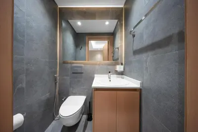a bathroom with a sink and a toilet and a mirror at Brand-New Elegant Stay Premium Amenities JVT in Dubai