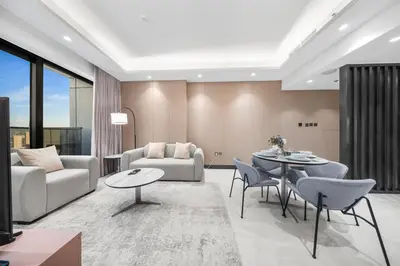 a living room with a couch and a table and chairs at Brand-New Elegant Stay Premium Amenities JVT in Dubai