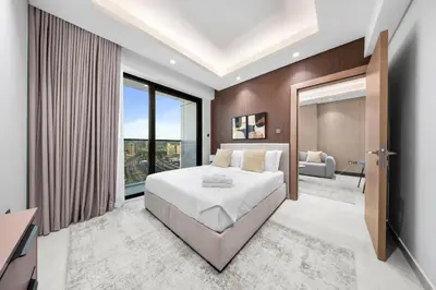 a bedroom with a bed and a large window at Brand-New Elegant Stay Premium Amenities JVT in Dubai