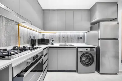 a kitchen with a washing machine and a washer at Brand-New Elegant Stay & Premium Amenities in JVT in Dubai