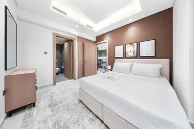 a bedroom with a large bed and a television at Brand-New Elegant Stay & Premium Amenities in JVT in Dubai