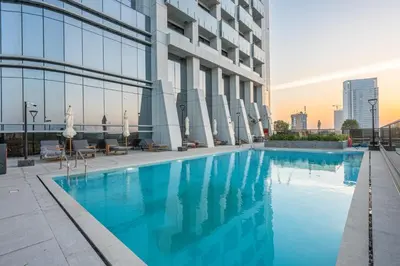 a swimming pool in front of a building at Brand-New Elegant Stay & Premium Amenities in JVT in Dubai