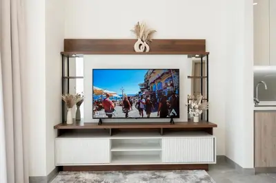 a television on a entertainment center in a living room at 1BR - Peninsula One in Dubai