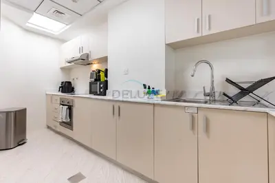 a kitchen with white cabinets and a sink at 2BR, Seaside Serenity, Sea View - Torch Tower, Dubai Marina by Deluxe Holiday Homes in Dubai