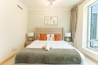 a bedroom with a large bed with orange pillows at HAVN - 1 Bedroom in Downtown Dubai in Dubai