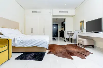 a bedroom with a bed and a desk and a television at Nasma Luxury stays - Executive stay with hotel facilities in Dubai
