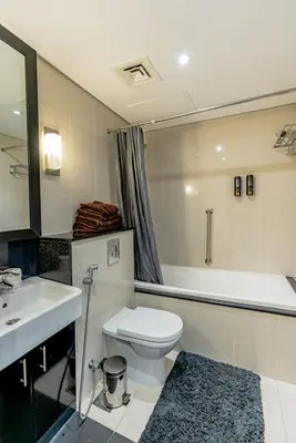 a bathroom with a toilet and a sink and a tub at Nasma Luxury stays - Executive stay with hotel facilities in Dubai