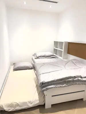 a bedroom with two beds in a white room at Elegant apartment in a prime location in Dubai