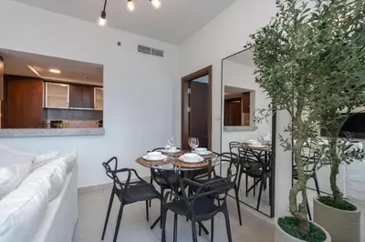 a living room with a table and chairs and a couch at Bright, modern flat on the Marina Promenade in Dubai