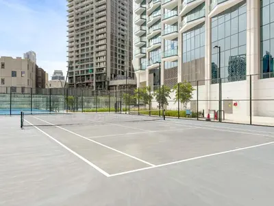a tennis court in front of a tall building at VayK - Luxury 1 BD with Panoramic Canal Views in Dubai