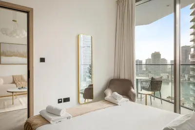 a bedroom with a bed and a view of a city at VayK - Luxury 1 BD with Panoramic Canal Views in Dubai