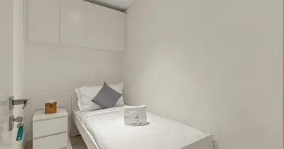 a white room with a bed with a pillow at Luxury 3BHK & Maid Sea View & Private Beach in Sabkhah