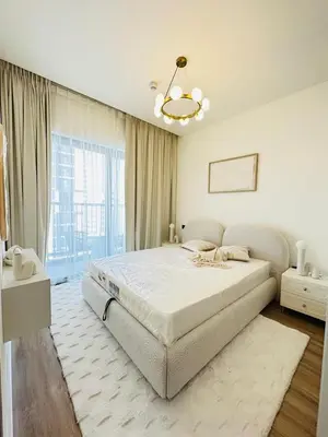 a white bedroom with a large bed and a chandelier at Superb 1BR high floor apartment on Sobha Hartland in Dubai