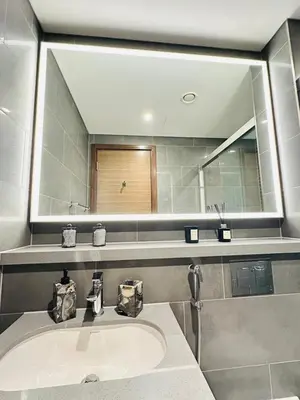 a bathroom with a sink and a large mirror at Superb 1BR high floor apartment on Sobha Hartland in Dubai