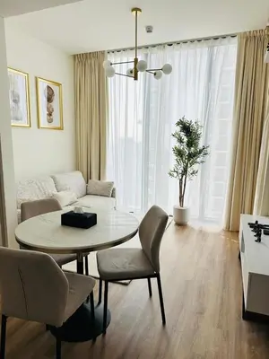 a living room with a table and chairs and a couch at Superb 1BR high floor apartment on Sobha Hartland in Dubai