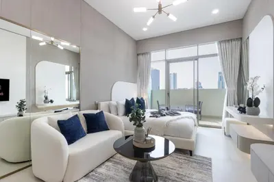 a living room with a couch and a bed at Elegant Designer Studio with Balcony & Rooftop Pool in JVC in Dubai