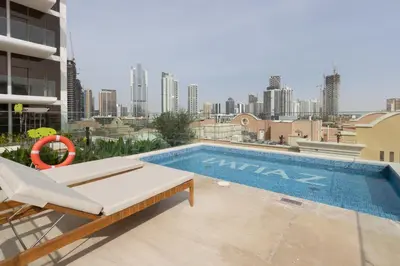 a swimming pool on the roof of a building at Elegant Designer Studio with Balcony & Rooftop Pool in JVC in Dubai