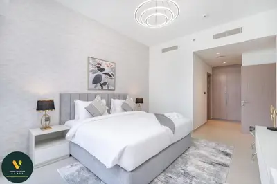 a white bedroom with a large white bed in it at Vogue Downtown Act One near Burj Khalifa and Dubai Mall, Two Bedroom Apartment with Balcony and City Skyline View, Access to all Amenities in Dubai