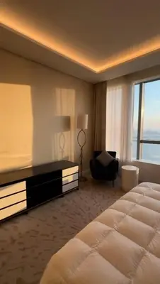 a hotel room with a large bed and a chair at PALM TOWER by Design Studio 1 BR in Dubai