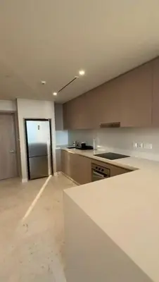 a large white kitchen with a counter and a door at PALM TOWER by Design Studio 1 BR in Dubai
