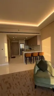 a living room with a couch and a kitchen at PALM TOWER by Design Studio 1 BR in Dubai