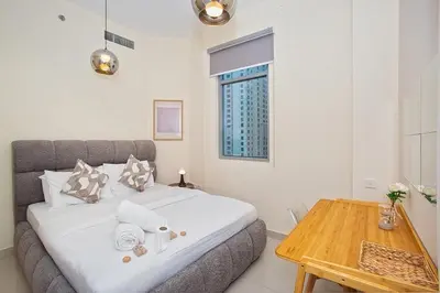 a bedroom with a bed and a wooden table at Stunning 2 Bedroom Apartment in JBR with Balcony in Dubai