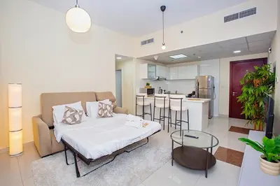 a living room with a bed and a kitchen at Stunning 2 Bedroom Apartment in JBR with Balcony in Dubai