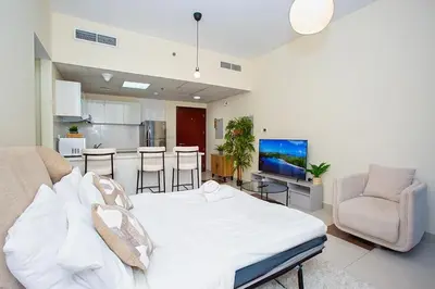 a bedroom with a white bed and a kitchen at Stunning 2 Bedroom Apartment in JBR with Balcony in Dubai