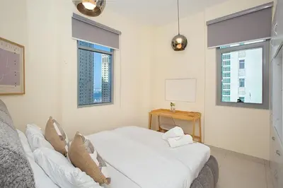 a white room with a bed and two windows at Stunning 2 Bedroom Apartment in JBR with Balcony in Dubai