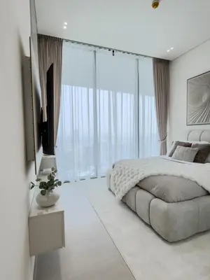 a bedroom with a large bed and a television at Luxe Apt with Private Balcony Pool in Dubai