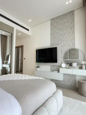 a white bedroom with a large bed and a flat screen tv at Luxe Apt with Private Balcony Pool in Dubai