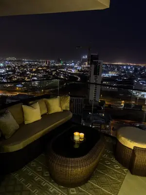 a living room with a couch and a view of a city at night at Luxe Apt with Private Balcony Pool in Dubai