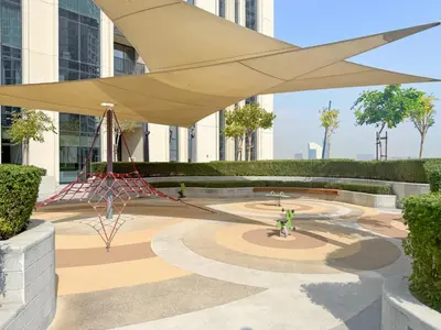 a large tan umbrella in a courtyard in a building at Premium 2BR with Park View in Dubai Creek Harbour in Dubai