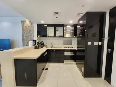 a kitchen with black cabinets and white counter tops at Golden Grove 1 Bhk Bays Edge 1 Business bay in Dubai