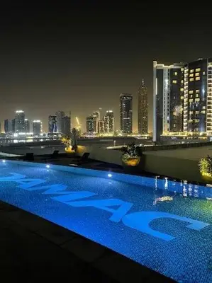 a swimming pool with a city skyline at night at Golden Grove 1 Bhk Bays Edge 1 Business bay in Dubai